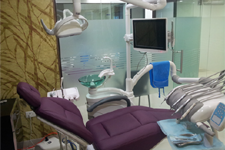 Clean dental clinic setup with a yellow dental chair and wall-mounted tools